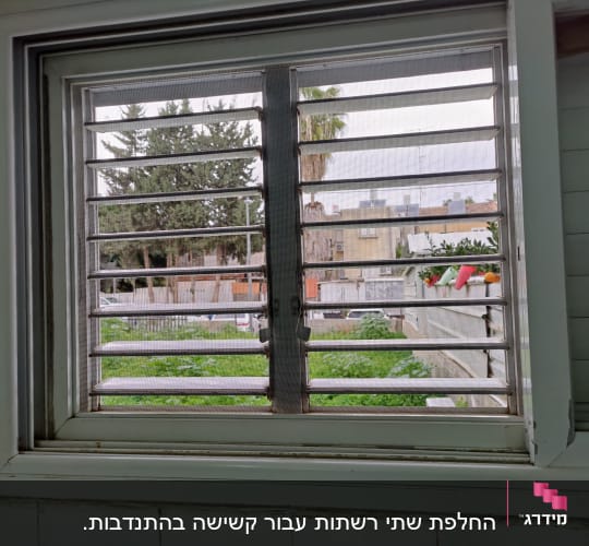 תריסי אלומיניום בחלון עם נוף חיצוני